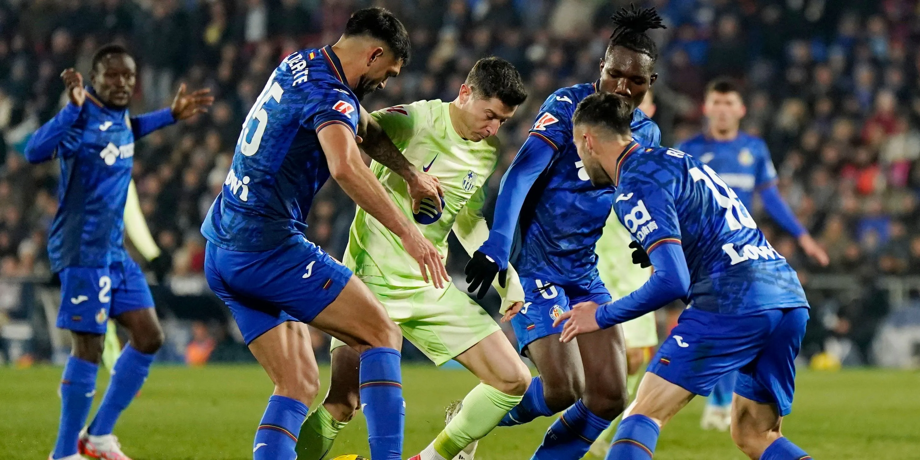 Christantus Uche và Omar Alderete của Getafe trong trận đấu với Robert Lewandowski của Barcelona